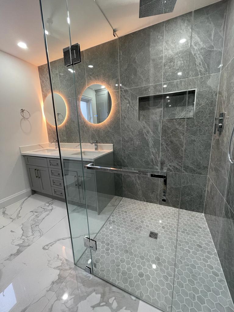 Stylish bathroom renovation with freestanding tub and rainfall shower in GTA and Niagara Region.